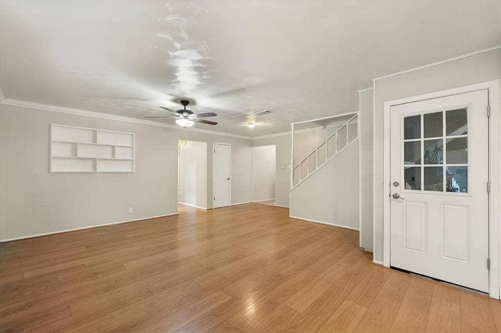 144 Jill Ann Drive, Burleson, TX 76028 Wood-finish flooring, ceiling fan with integrated lighting, built-in wall shelving, crown molding, and a paneled door with glass inserts