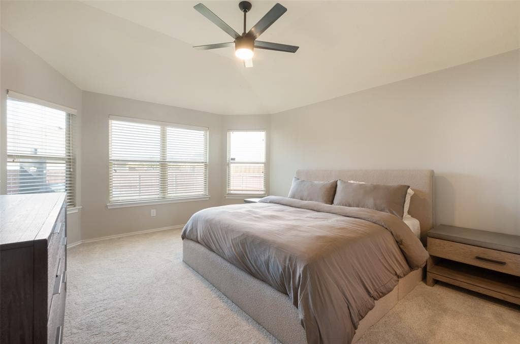 1929 Day Break Drive, Lancaster, TX 75146 Vaulted ceiling with a flush-mount ceiling fan, multiple windows with blinds, and neutral carpeting