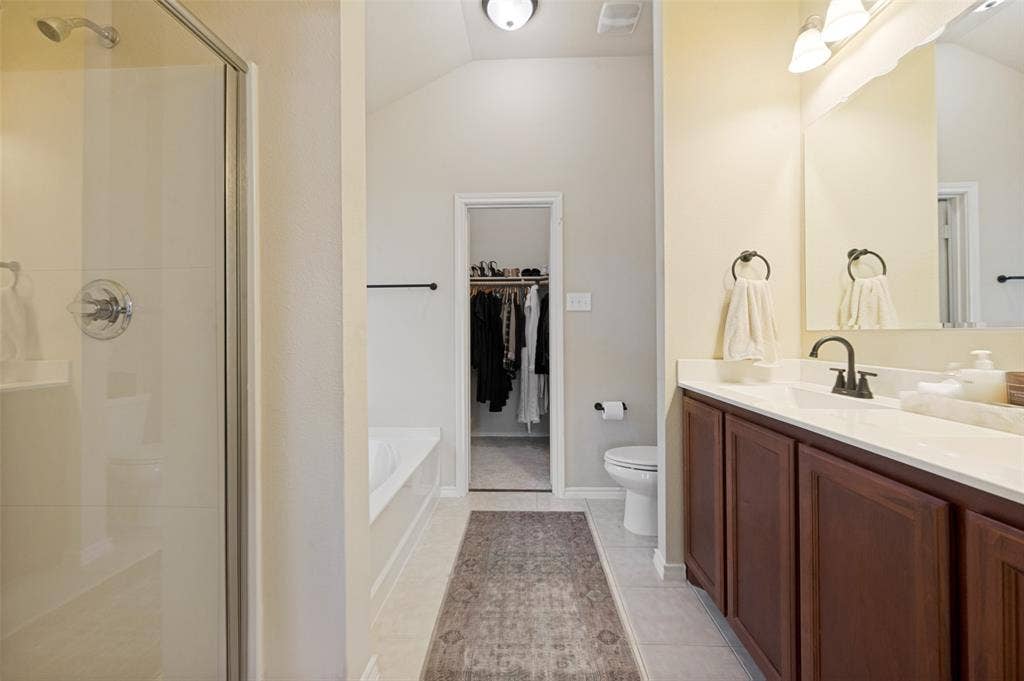 1929 Day Break Drive, Lancaster, TX 75146 Bathroom featuring a glass-enclosed shower, built-in bathtub, dual-basin vanity with dark wood-finish cabinetry, and a walk-in closet