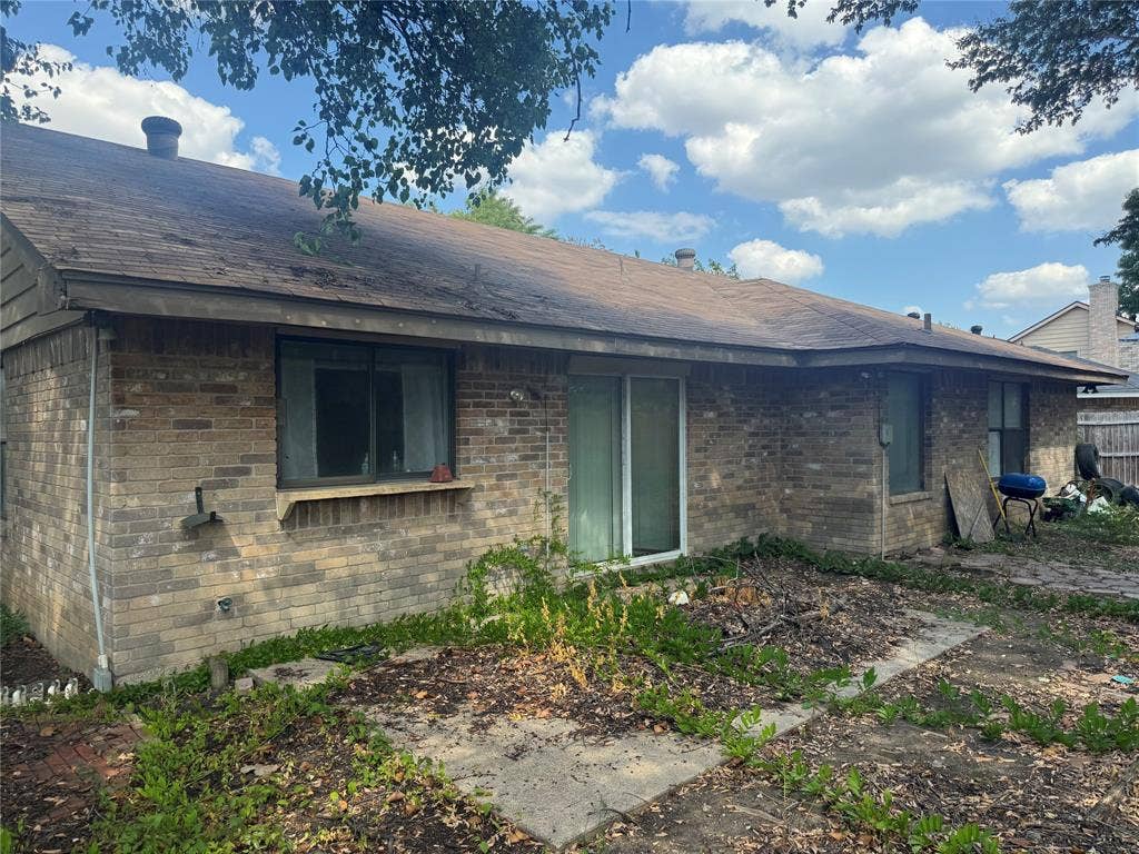 2681 Steppington Street, Grand Prairie, TX 75052 Brick exterior with a brown shingle roof and a sliding glass door