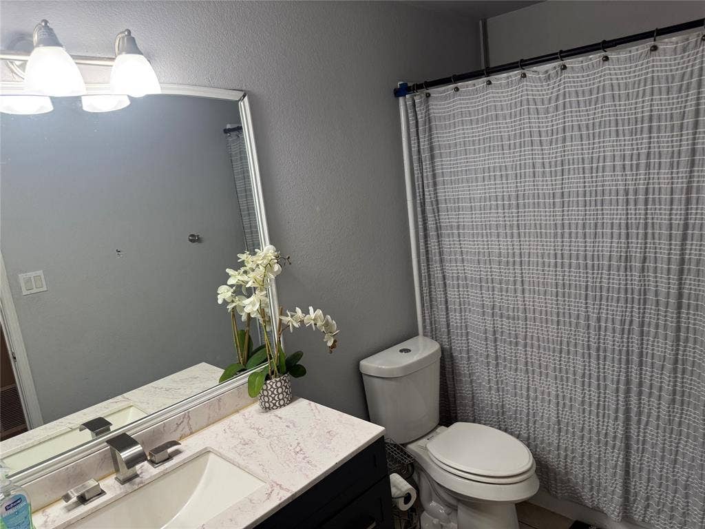 2681 Steppington Street, Grand Prairie, TX 75052 Vanity with a rectangular sink, polished chrome faucet, and stone-finish countertop
