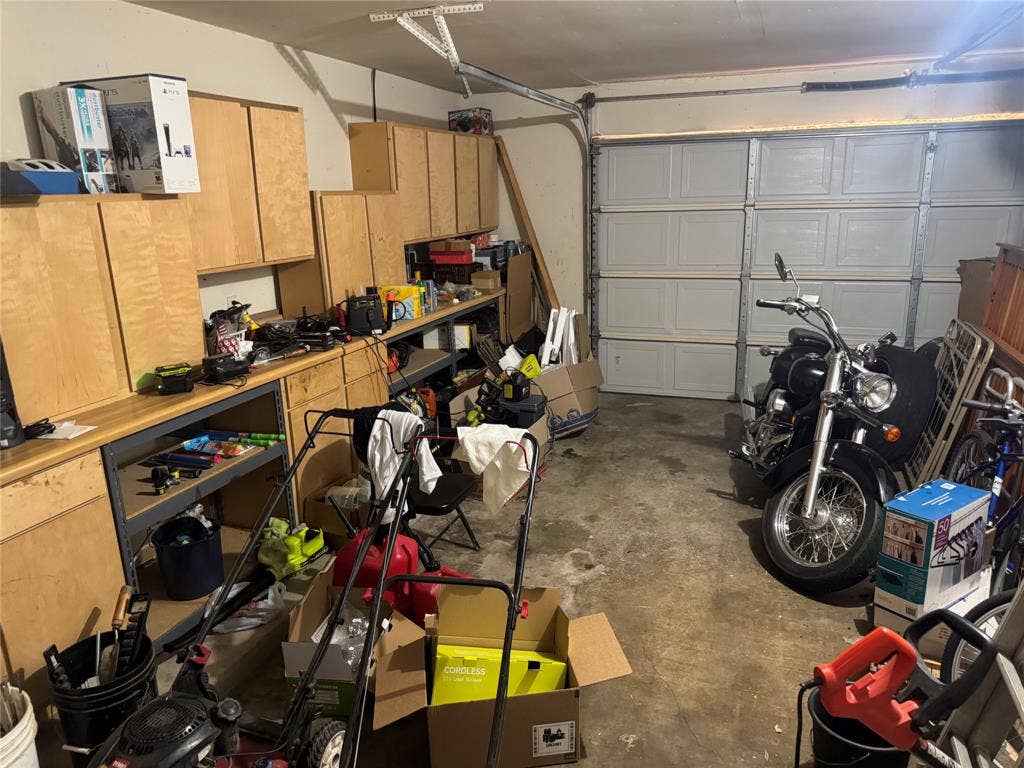 2681 Steppington Street, Grand Prairie, TX 75052 Garage with built-in cabinetry, workbench, and panel garage door