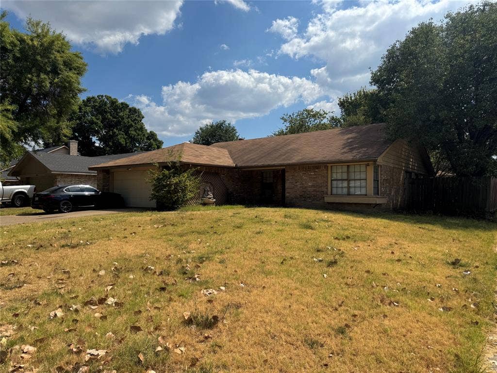 2681 Steppington Street, Grand Prairie, TX 75052 Brick exterior with a single-panel garage door and a concrete driveway