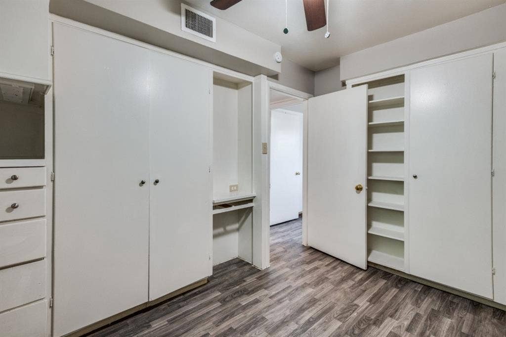 2213 Capri Drive, #208, Fort Worth, TX 76114 Wood-finish flooring throughout, integrated cabinetry, built-in shelving, and a ceiling fan