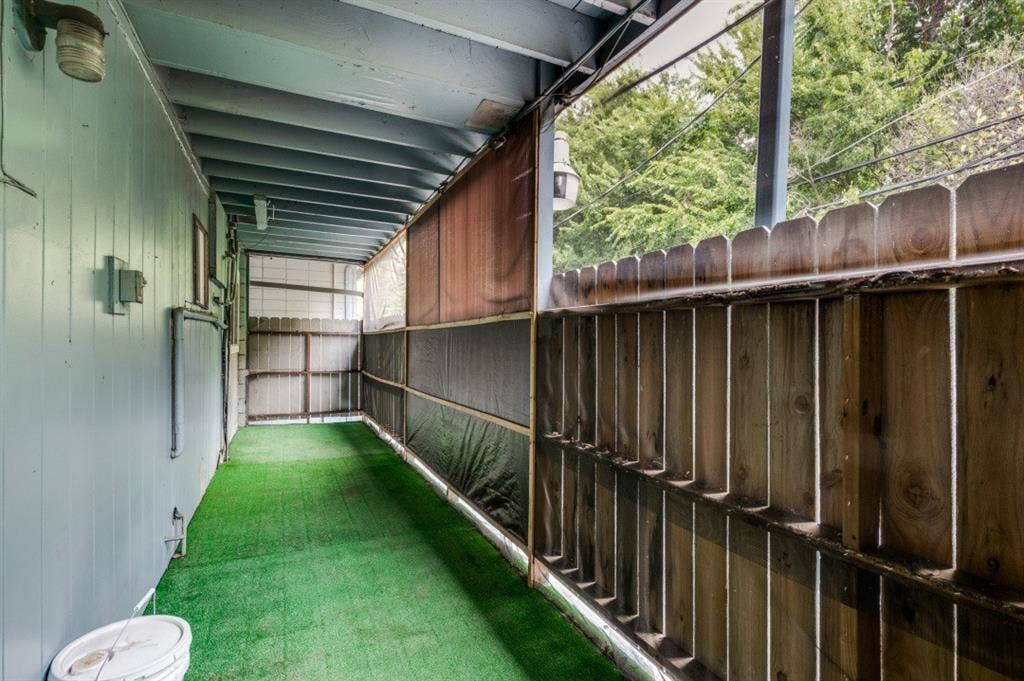2213 Capri Drive, #208, Fort Worth, TX 76114 Covered outdoor area featuring synthetic turf flooring, wooden privacy fencing, and exposed beam ceiling