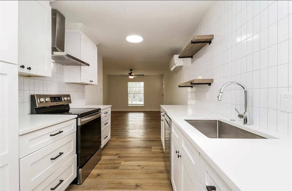 425 N Rosemont Avenue, #111, Dallas, TX 75208 Modern kitchen featuring white cabinetry, stainless steel appliances, white subway tile backsplash, and wood-finish flooring
