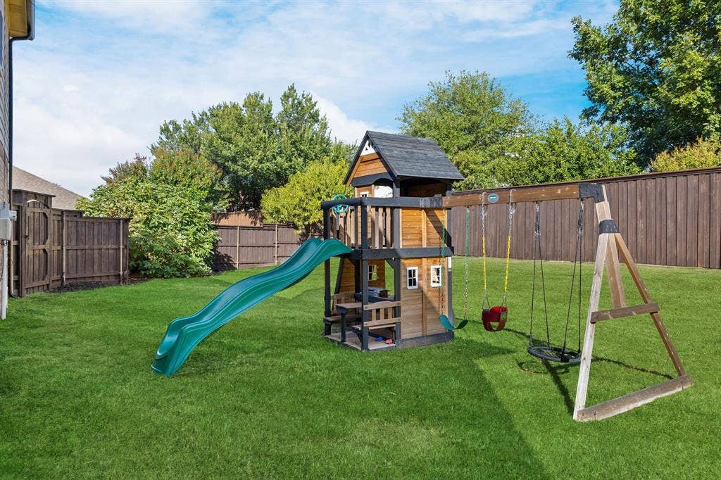 239 Glen Ridge Drive, Murphy, TX 75094 Expansive grassy lawn with a wood privacy fence and mature trees