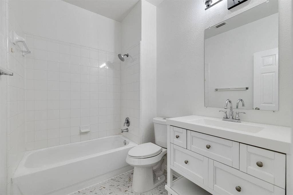 239 Glen Ridge Drive, Murphy, TX 75094 White vanity with integrated sink, chrome faucet, and rectangular mirror