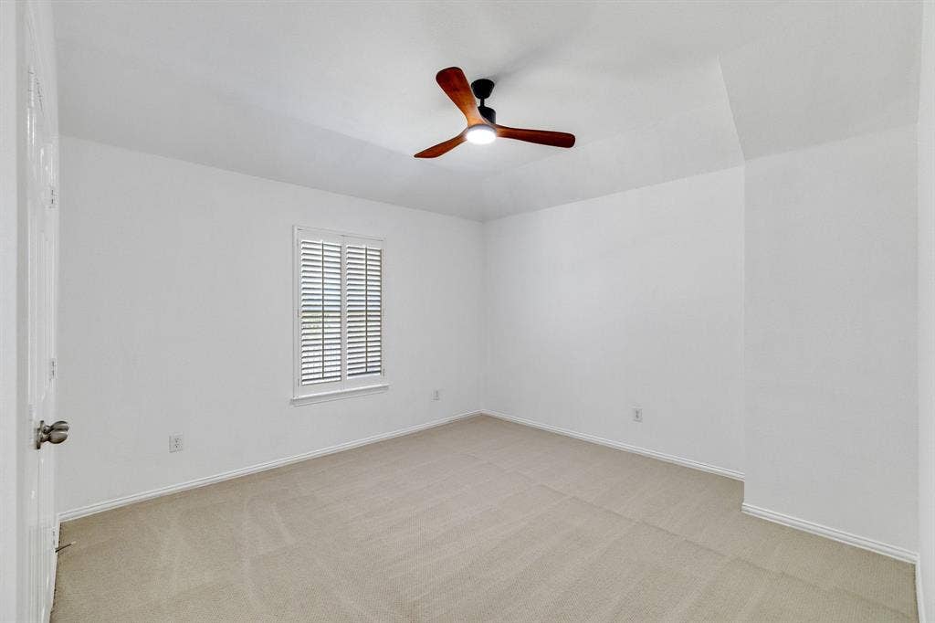 239 Glen Ridge Drive, Murphy, TX 75094 Recessed window with plantation shutters, neutral carpeting, and a ceiling fan with integrated lighting