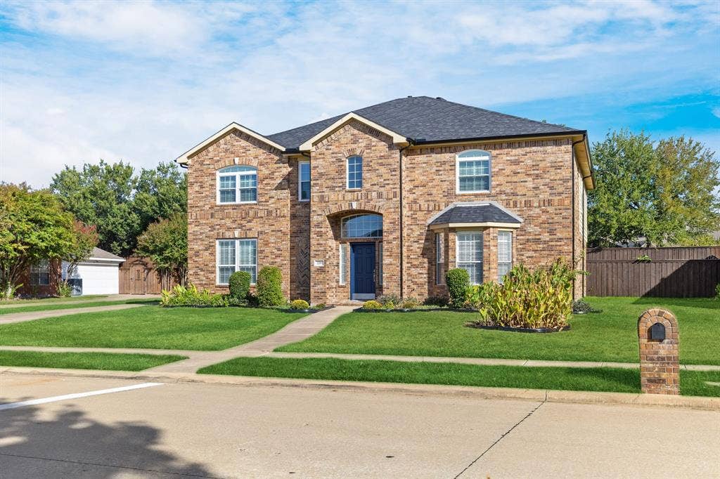 239 Glen Ridge Drive, Murphy, TX 75094 Brick exterior with a dark roof and multiple arched windows