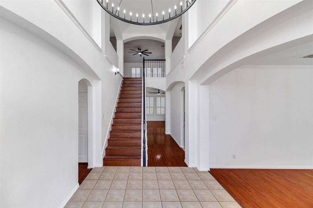 239 Glen Ridge Drive, Murphy, TX 75094 Two-story entryway with a decorative chandelier, a wood staircase, and an arched entry