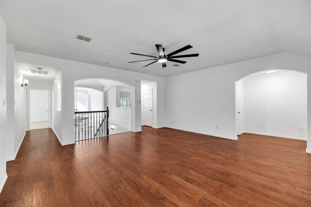 239 Glen Ridge Drive, Murphy, TX 75094 Hardwood-finish flooring, recessed lighting, contemporary ceiling fan, arched doorways, and wrought iron balusters