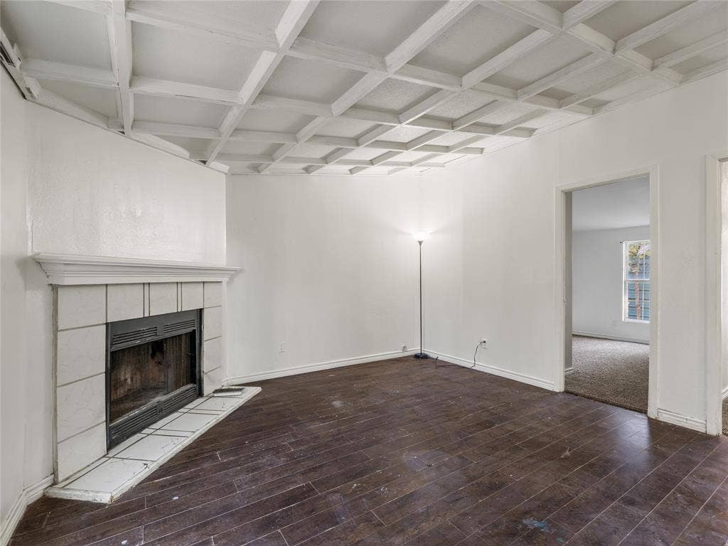 Coffered ceiling with a white finish, tile-surround fireplace with a mantel, and dark wood-finish flooring
