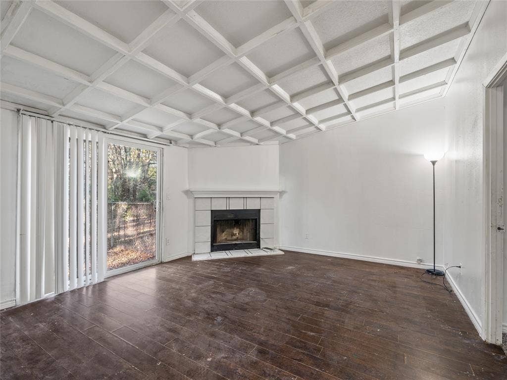 Living area featuring a coffered ceiling, wood-finish flooring, a fireplace with a tile surround, and a sliding glass door