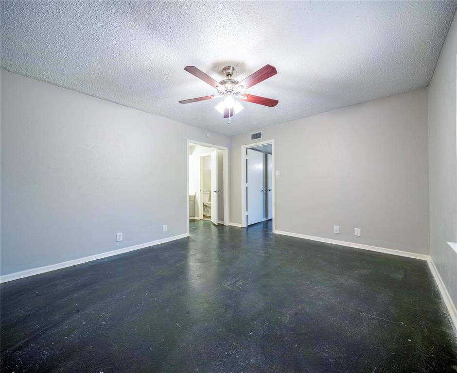 1717 N Locust Street, #1, Denton, TX 76201 Smooth dark flooring, light gray walls, ceiling fan with integrated lighting, and white trim