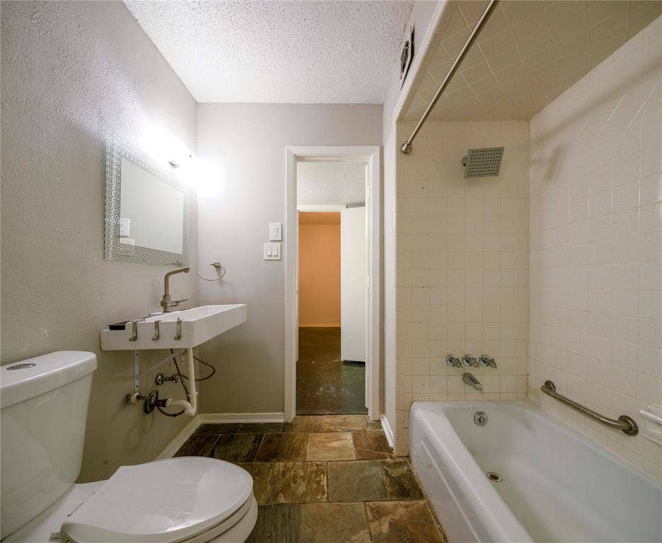 1717 N Locust Street, #1, Denton, TX 76201 Rectangular vessel sink with wall-mounted faucet, mosaic-framed mirror, and a full bathtub with a rain shower head