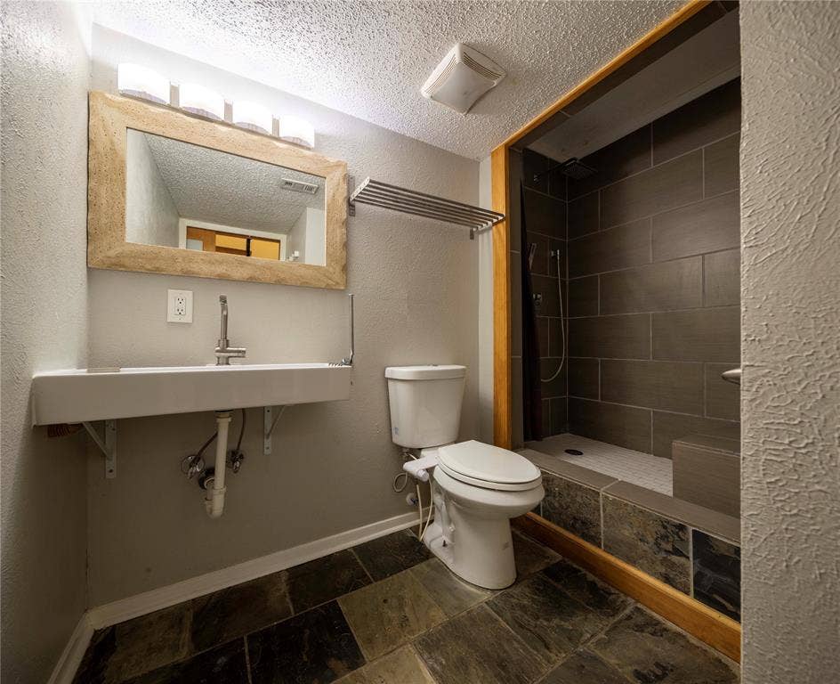 1717 N Locust Street, #1, Denton, TX 76201 Walk-in shower with dark gray tile surround and built-in bench