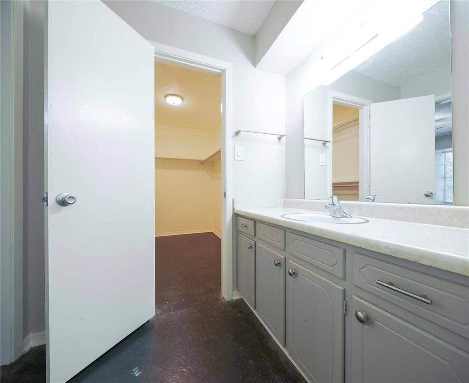 1717 N Locust Street, #1, Denton, TX 76201 Vanity with an integrated sink, polished chrome faucet, and gray cabinetry with silver hardware