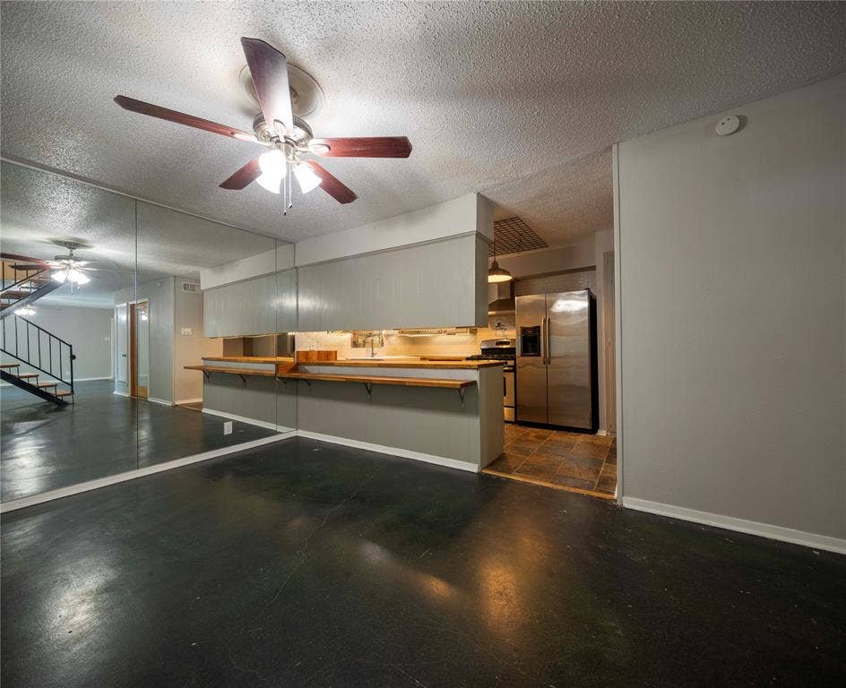 1717 N Locust Street, #1, Denton, TX 76201 Open-concept living area featuring dark polished flooring and reflective mirrored wall panels