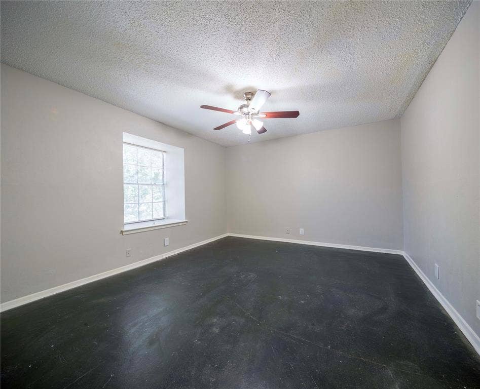 1717 N Locust Street, #1, Denton, TX 76201 Neutral wall paint with textured ceiling, ceiling fan with light fixture, and window with white trim
