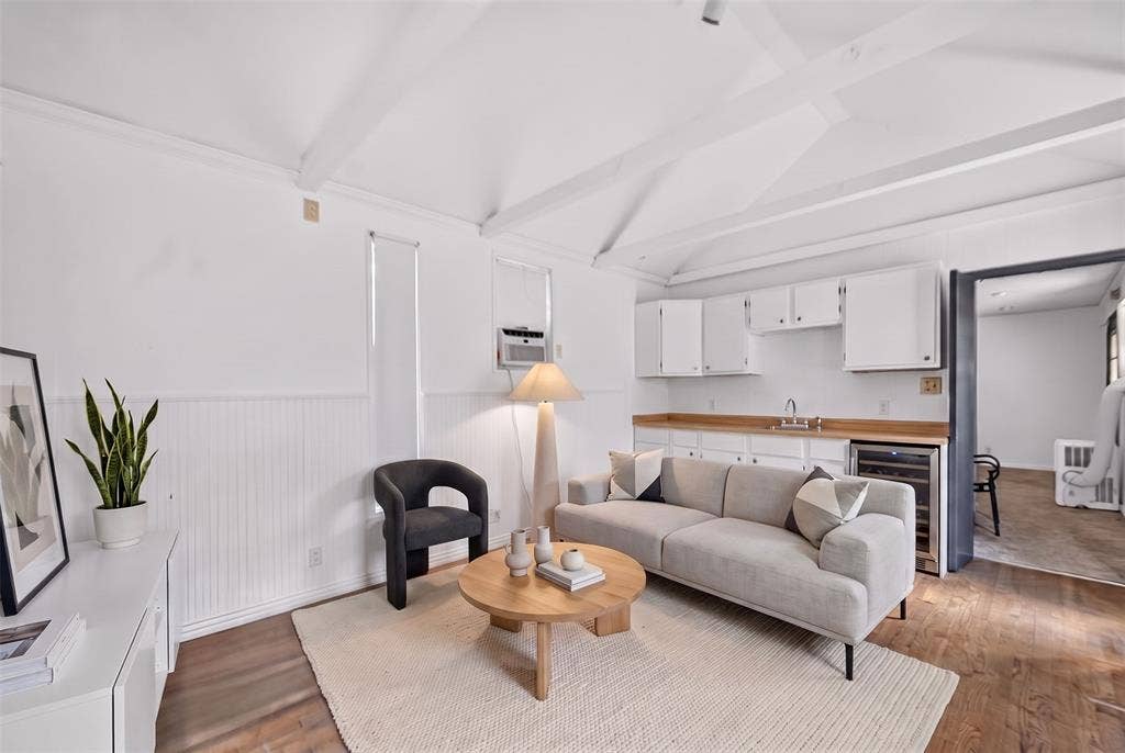 5630 Vanderbilt Avenue, Dallas, TX 75206 Vaulted beamed ceiling over a kitchenette with white cabinetry, wood-finish countertops, and a built-in beverage refrigerator