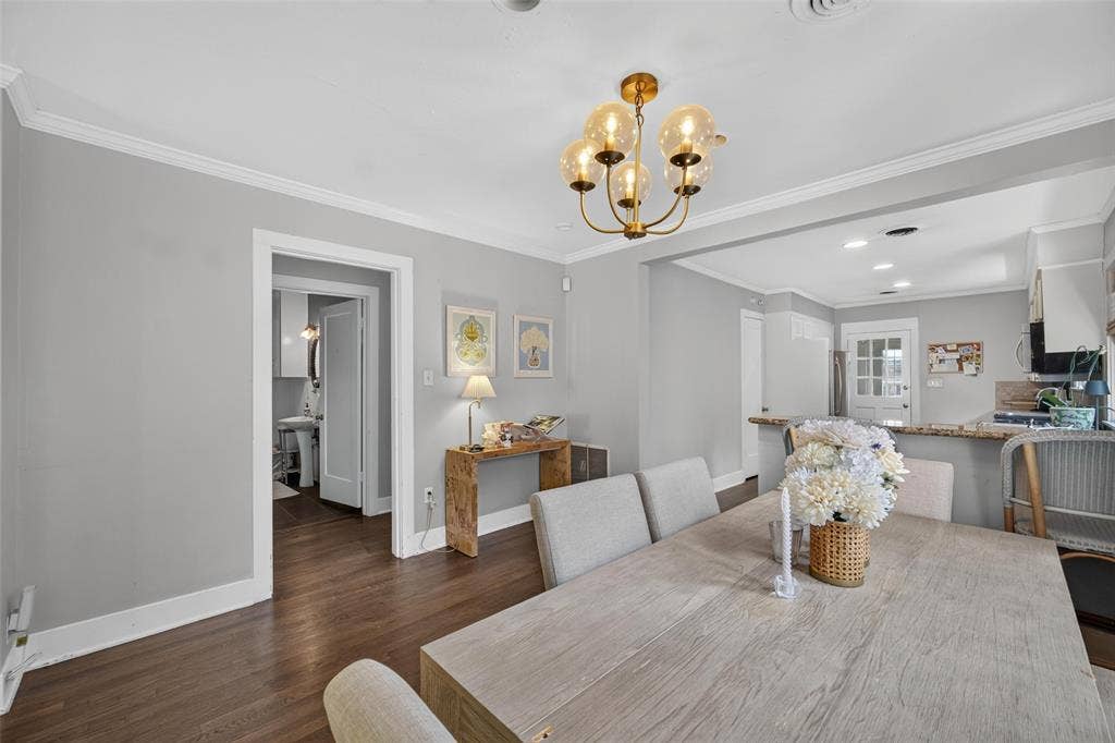 5630 Vanderbilt Avenue, Dallas, TX 75206 Hardwood flooring, crown molding, cased doorways, recessed lighting, and a brass chandelier