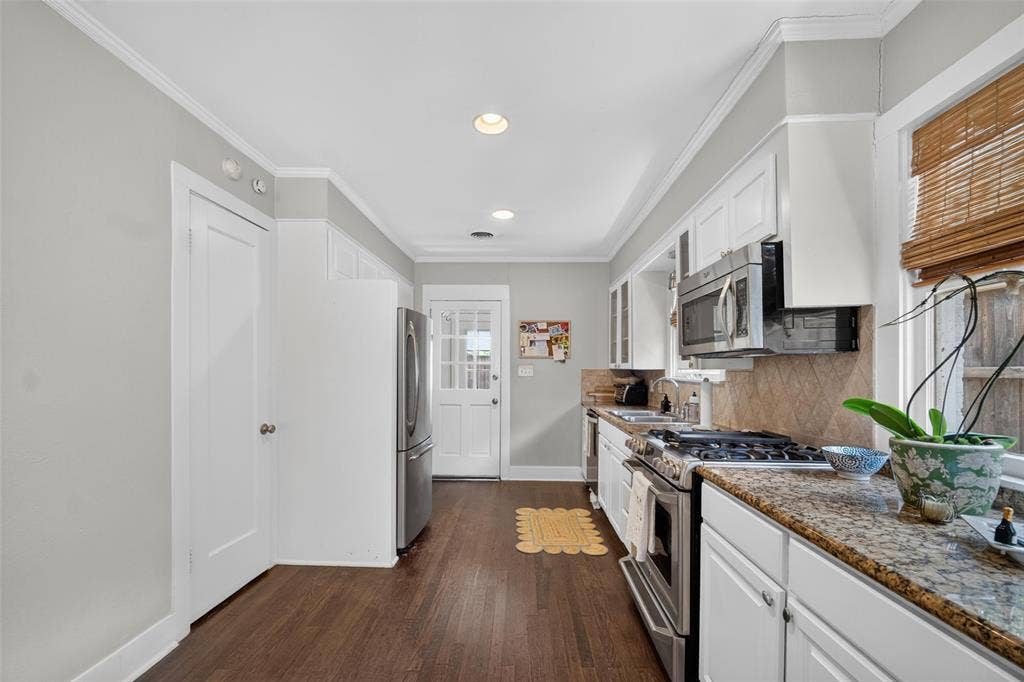 5630 Vanderbilt Avenue, Dallas, TX 75206 Kitchen featuring wood-finish flooring, white cabinetry, a built-in stainless steel microwave, and granite countertops