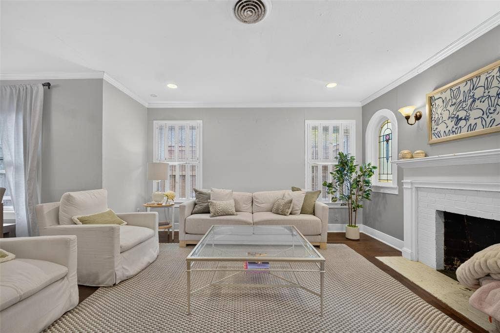 5630 Vanderbilt Avenue, Dallas, TX 75206 Recessed lighting with crown molding, wood-finish flooring, and a fireplace with a white mantel and hearth