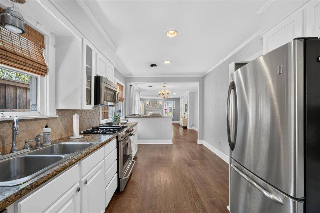 5630 Vanderbilt Avenue, Dallas, TX 75206 Stainless steel appliances, wood-finish flooring, white cabinetry, integrated double basin sink, and recessed lighting