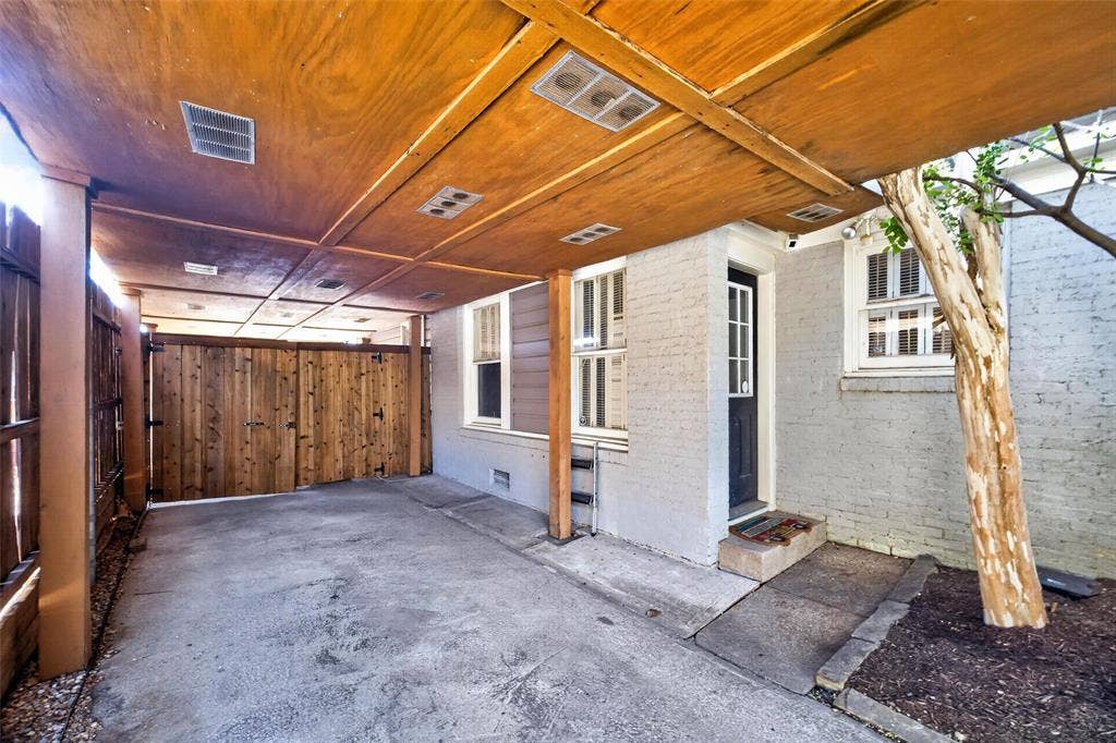 5630 Vanderbilt Avenue, Dallas, TX 75206 Covered carport featuring a wood-finish ceiling with recessed lighting, concrete flooring, and a privacy gate