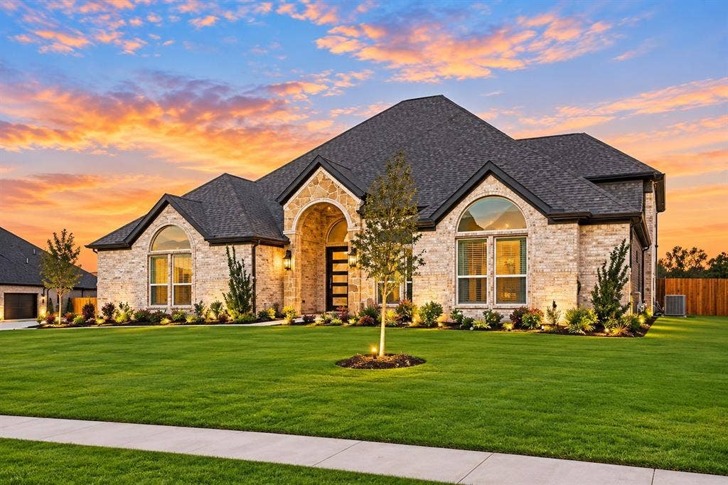 Stone and brick exterior with a dark shingle roof