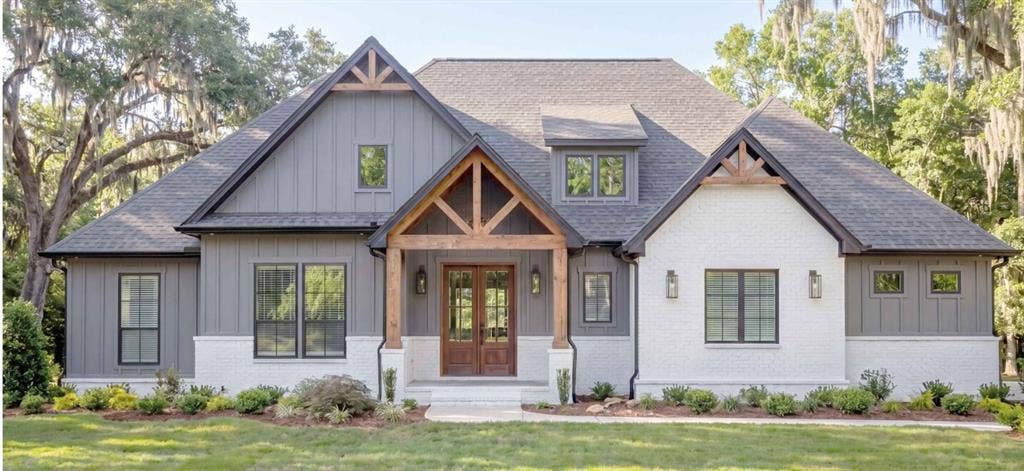 23500 Champion Drive, Lindale, TX 75771 Contemporary farmhouse exterior featuring board and batten siding, brick accents, a prominent gable porch with wood beam detailing, a dark shingle roof, and a double-door entry
