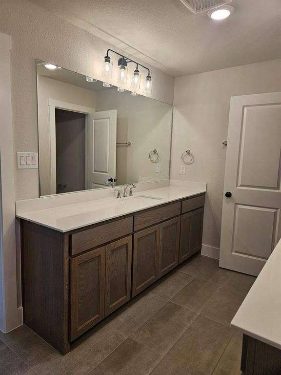 221 Chestnut Street, Celina, TX 75009 Double vanity with light wood-finish cabinetry and white countertops