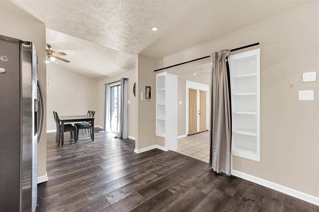 108 Kingsbridge Drive, Garland, TX 75040 Wood-finish flooring throughout, vaulted ceiling, recessed lighting, built-in shelving, and a sliding glass door