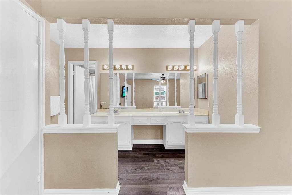108 Kingsbridge Drive, Garland, TX 75040 Dual vanity with white countertop and integrated sinks, individual mirrors, and wood-finish flooring