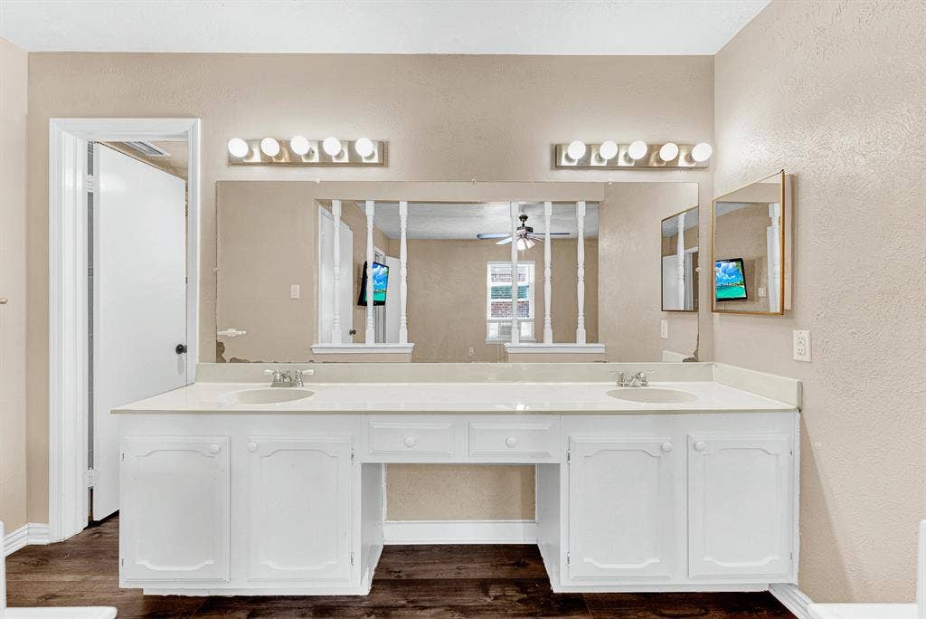 108 Kingsbridge Drive, Garland, TX 75040 Walk-in shower with etched glass sliding doors, vanity with a white countertop and base cabinetry, wall-mounted mirror, and tile flooring