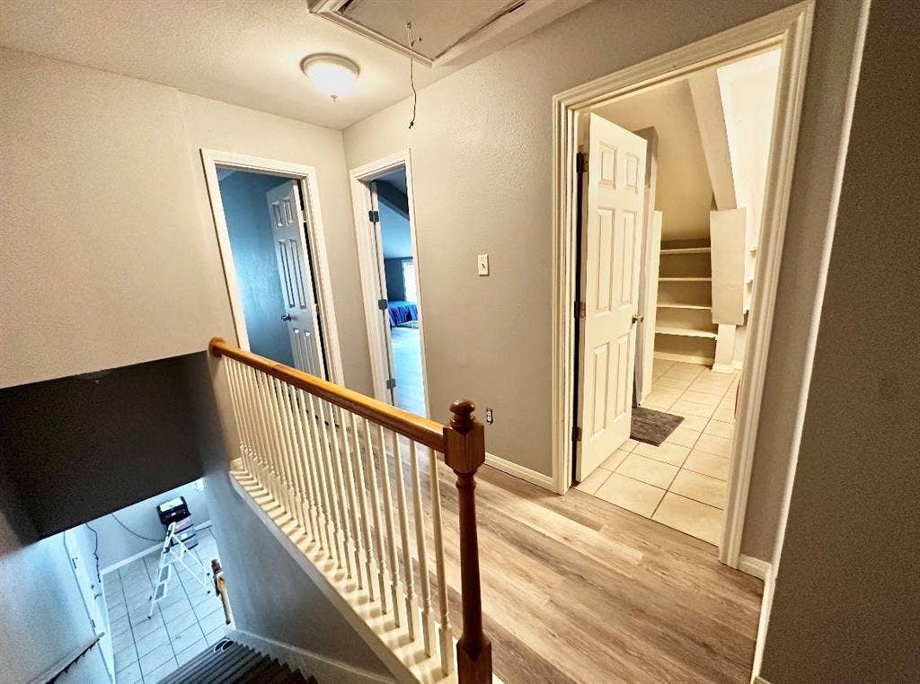 5205 Hudson Bend Road, Austin, TX 78734 Wood-finish flooring, white panel doors, and a wood handrail with white spindles