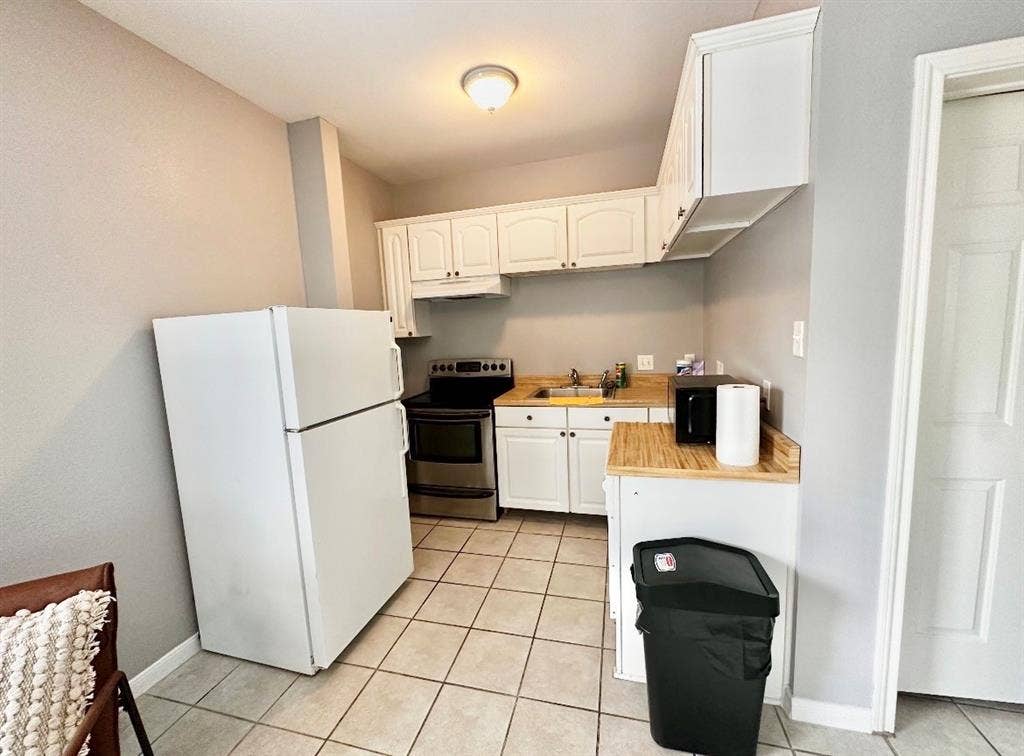 5205 Hudson Bend Road, Austin, TX 78734 Kitchen featuring white upper and lower cabinetry, wood-finish countertops, and a white refrigerator