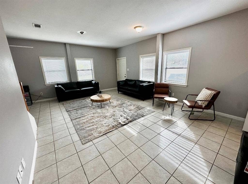 5205 Hudson Bend Road, Austin, TX 78734 Spacious interior featuring tile flooring, multiple windows with blinds, and light gray wall finishes