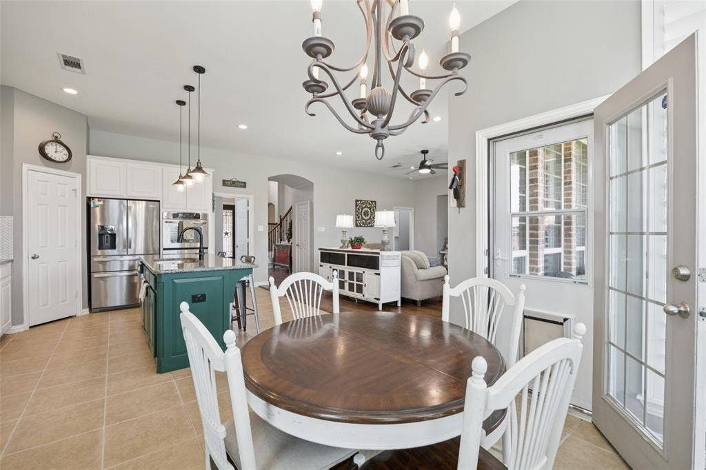 1000 Fenwick Lane, Forney, TX 75126 Kitchen featuring an island with a dark green base, stainless steel appliances, and white cabinetry