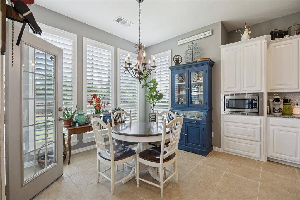 1000 Fenwick Lane, Forney, TX 75126 Tile flooring, white cabinetry, built-in microwave, chandelier lighting, and shuttered windows
