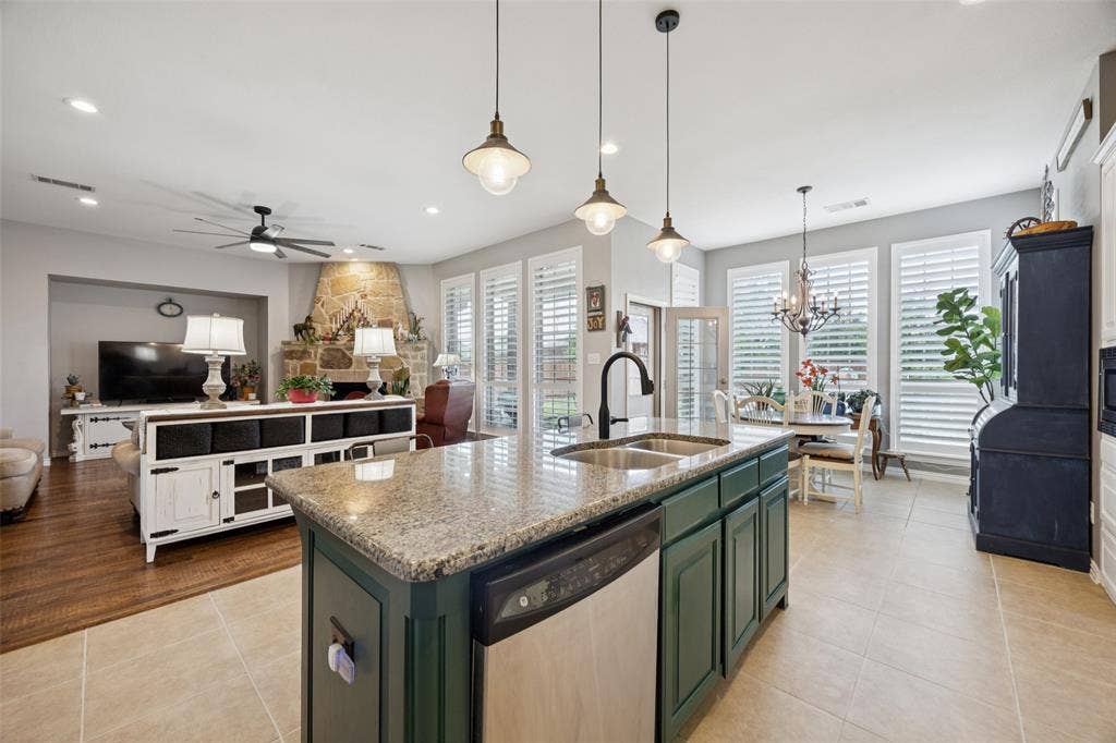 1000 Fenwick Lane, Forney, TX 75126 Kitchen island with a granite countertop, dual basin sink, and pendant lighting