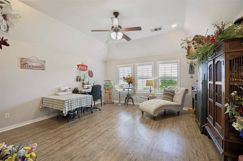 1000 Fenwick Lane, Forney, TX 75126 Vaulted ceiling with a ceiling fan, wood-finish flooring, recessed lighting, and three windows with plantation shutters