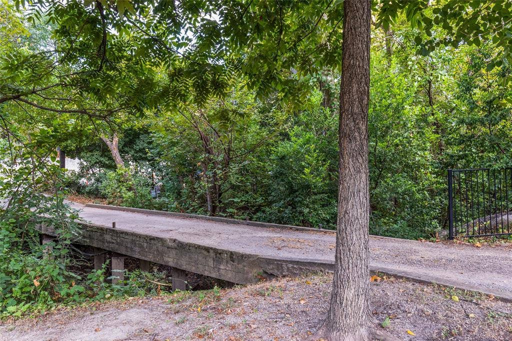 737 N Hampton Road, Dallas, TX 75208 The driveway crosses a bridge over the creek, creating a memorable arrival into the property.