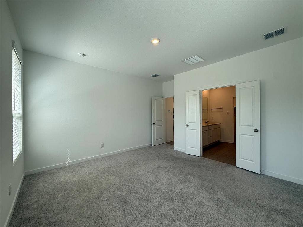 Plush gray carpeting, white walls, and a window with horizontal blinds