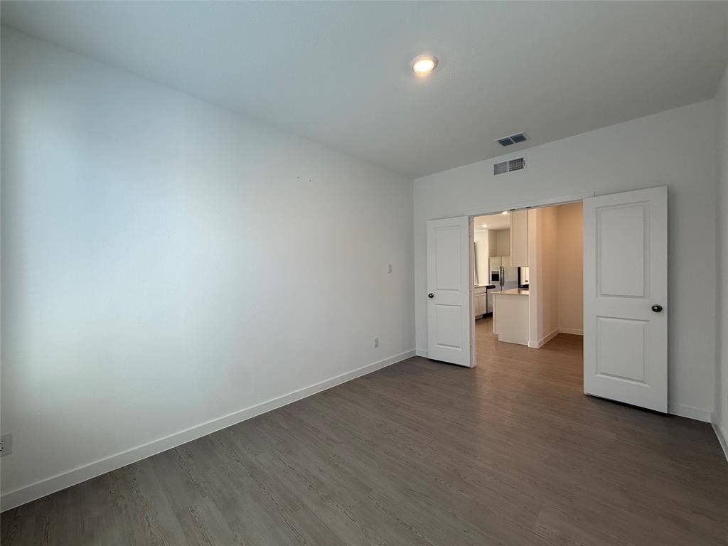 Neutral wall finishes, wood-finish flooring, recessed ceiling lighting, and double panel doors
