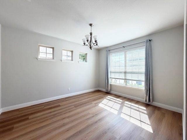 5609 Meritage Street, McKinney, TX 75070 Wood-finish flooring, recessed lighting, and a modern chandelier illuminate this bright room with multiple windows