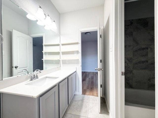 5609 Meritage Street, McKinney, TX 75070 Dual sink vanity with white countertop, chrome fixtures, and grey cabinetry