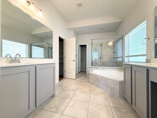 5609 Meritage Street, McKinney, TX 75070 Dual vanity with light gray cabinetry and white countertops, featuring a tiled soaking tub and a separate glass-enclosed shower