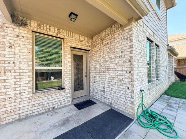 5609 Meritage Street, McKinney, TX 75070 Covered patio with a concrete slab, light brick exterior, and multiple windows
